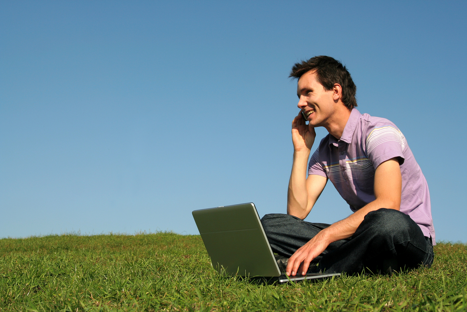 man using smartphone with laptop